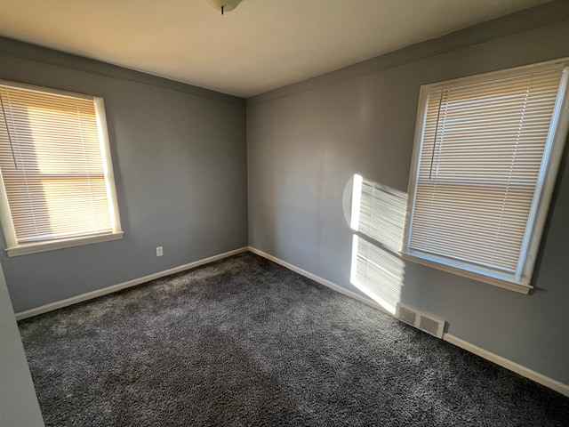 unfurnished room with dark colored carpet