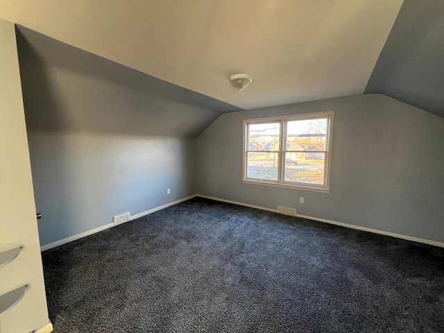 additional living space featuring lofted ceiling and carpet flooring