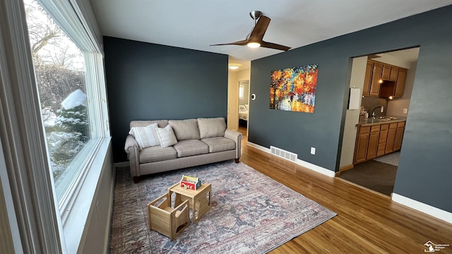 living room with ceiling fan, dark hardwood / wood-style floors, and sink