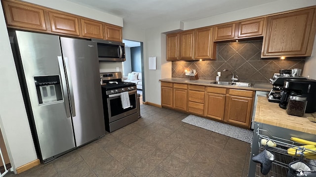 kitchen featuring stainless steel appliances, decorative backsplash, and sink