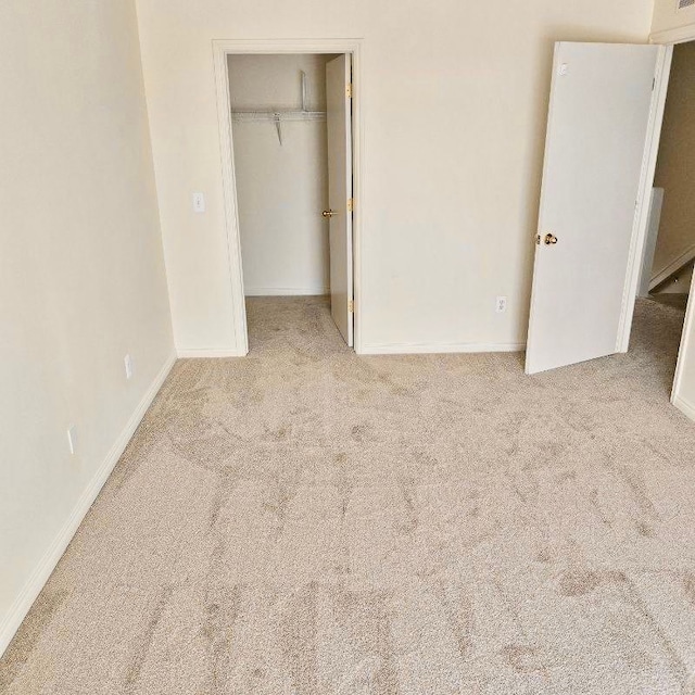 13319 St Ervin Ave Unit 17, Detroit, MI 48215 - unfurnished bedroom featuring light carpet, a spacious closet, baseboards, and a closet
