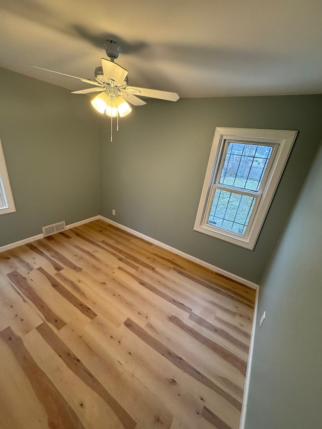 empty room with ceiling fan and light hardwood / wood-style floors