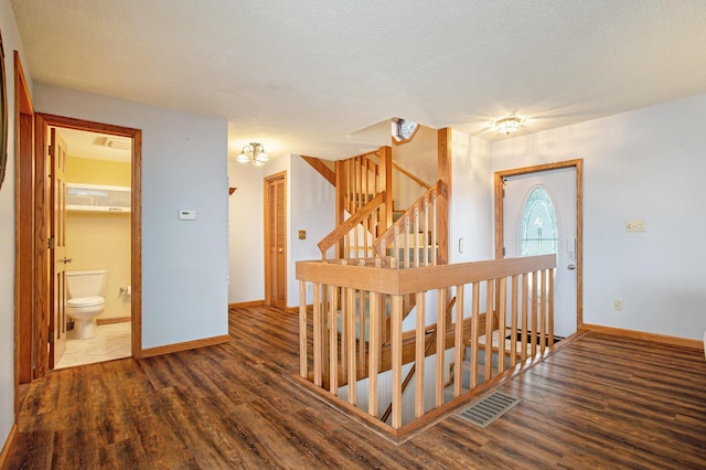 staircase with wood-type flooring and a textured ceiling