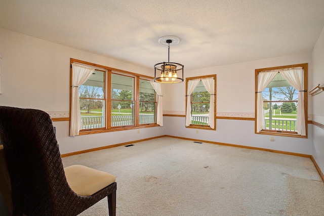 unfurnished dining area with carpet, a textured ceiling, and an inviting chandelier