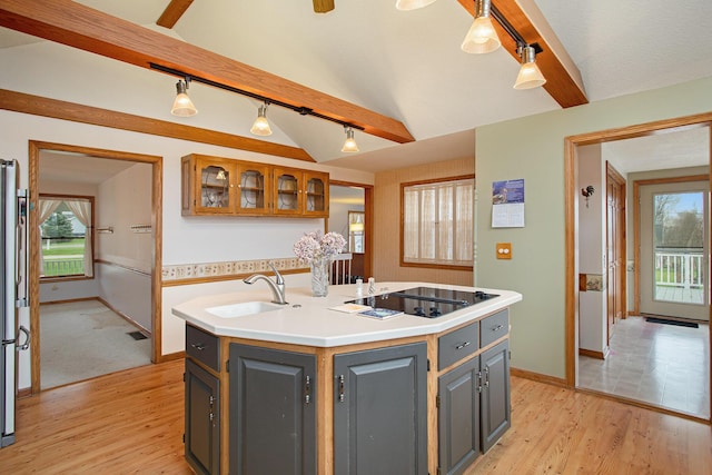 kitchen featuring a kitchen island with sink, sink, gray cabinets, and pendant lighting