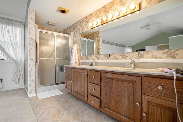 bathroom featuring ceiling fan, vanity, walk in shower, tile patterned floors, and a textured ceiling