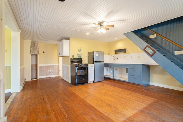 kitchen with ceiling fan, black range with electric stovetop, white cabinetry, light wood-type flooring, and stainless steel fridge