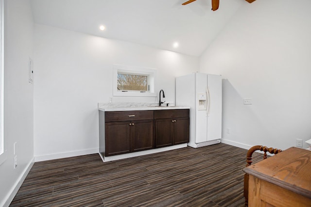 bar with ceiling fan, dark hardwood / wood-style floors, high vaulted ceiling, dark brown cabinets, and white fridge with ice dispenser