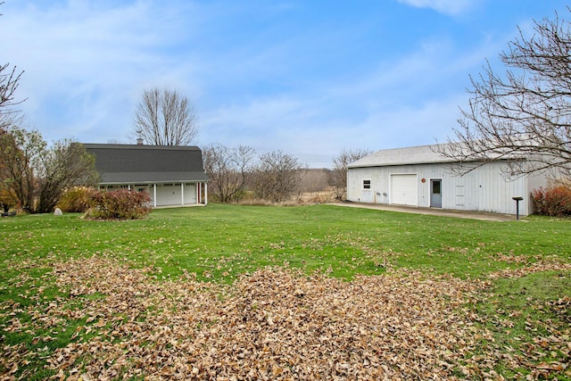 view of yard with a garage and an outdoor structure