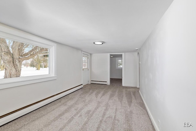 unfurnished room featuring a baseboard radiator and light carpet