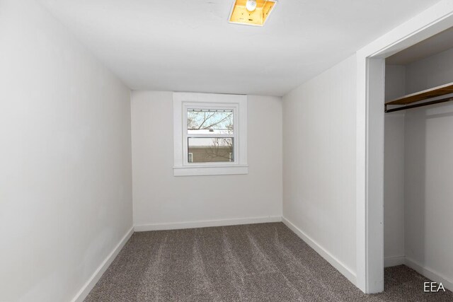 unfurnished bedroom with a closet and dark carpet