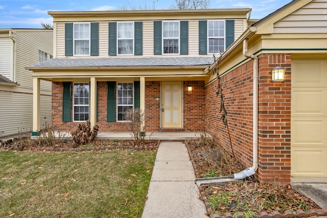 view of front of house with a garage, a front lawn, and a porch