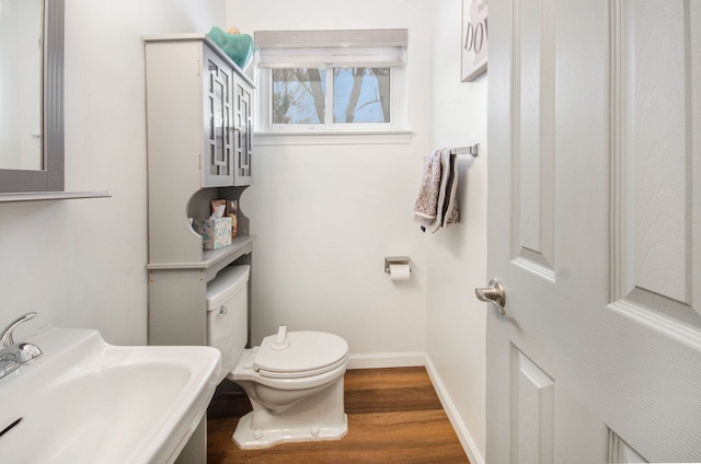 bathroom with toilet, sink, and hardwood / wood-style floors