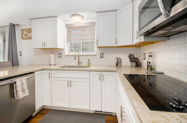 kitchen with stainless steel appliances, white cabinets, and sink