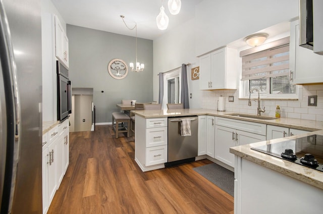 kitchen with white cabinetry, kitchen peninsula, stainless steel appliances, pendant lighting, and sink