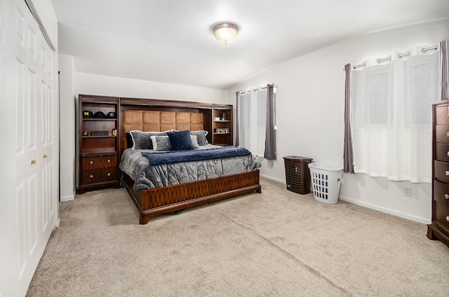 carpeted bedroom featuring a closet and vaulted ceiling