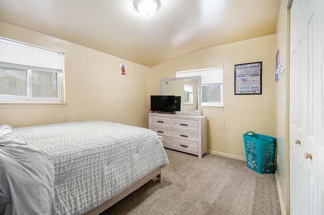 carpeted bedroom with vaulted ceiling and a closet