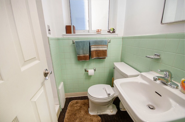 bathroom with sink, tile walls, and toilet