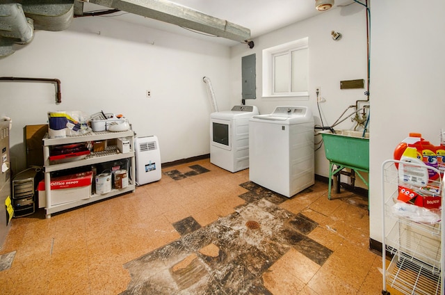 laundry area with electric panel, independent washer and dryer, and sink