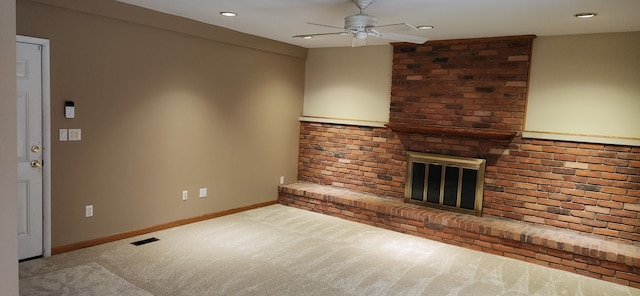 unfurnished living room with light carpet, ceiling fan, and a fireplace