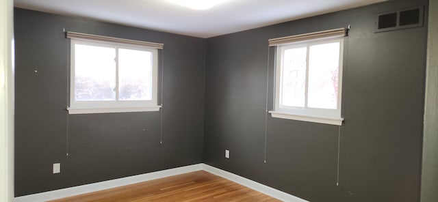 empty room featuring hardwood / wood-style flooring and plenty of natural light