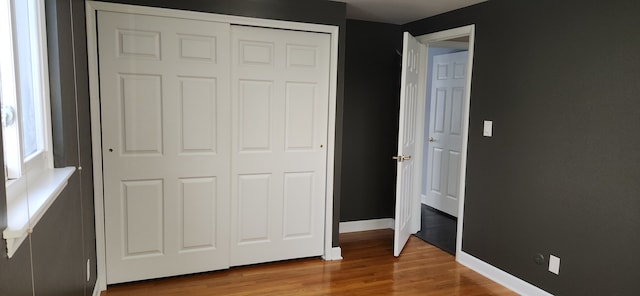 unfurnished bedroom featuring wood-type flooring and a closet