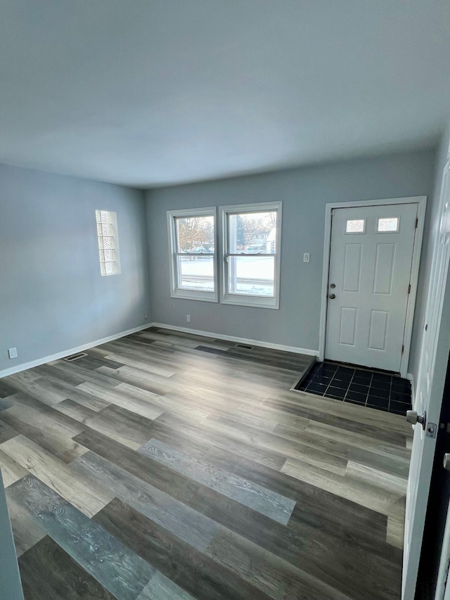 foyer featuring dark wood finished floors and baseboards