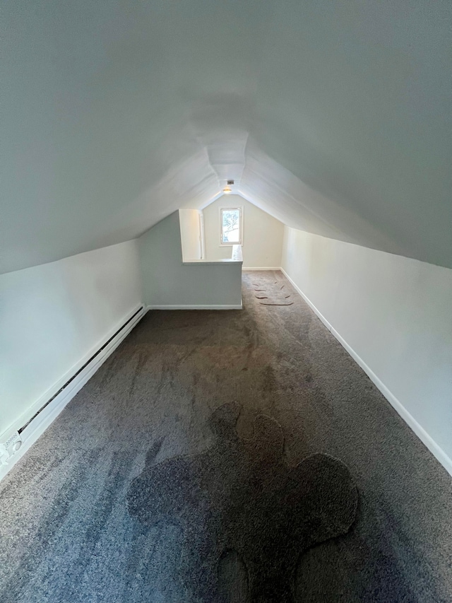 bonus room with baseboard heating, vaulted ceiling, and dark colored carpet