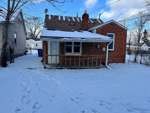 view of snow covered back of property