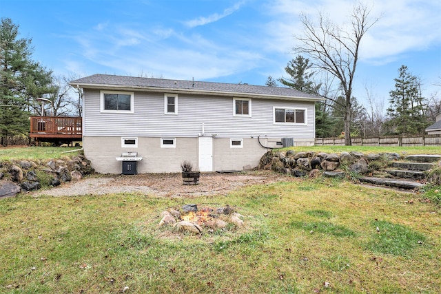 rear view of house with a deck, central air condition unit, and a lawn