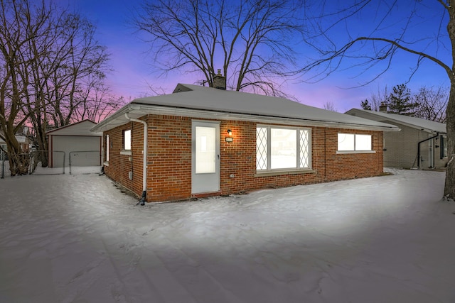 property exterior at dusk featuring a garage and an outdoor structure