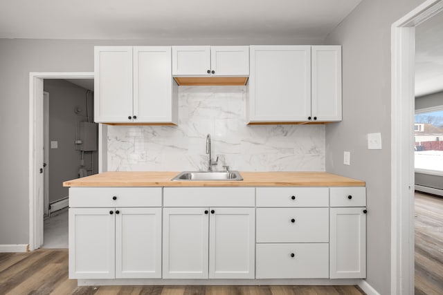 kitchen featuring white cabinets, butcher block countertops, and sink