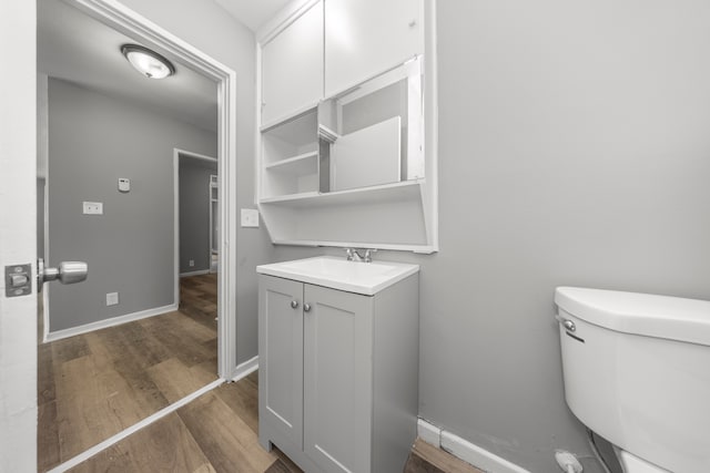 bathroom featuring hardwood / wood-style flooring, toilet, and vanity