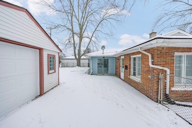 view of snow covered exterior featuring a garage