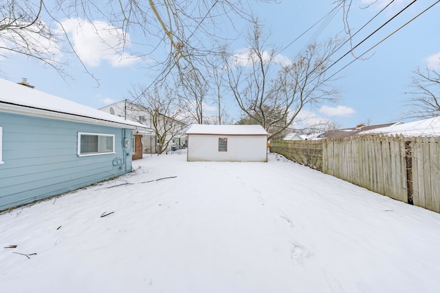 snowy yard featuring an outbuilding