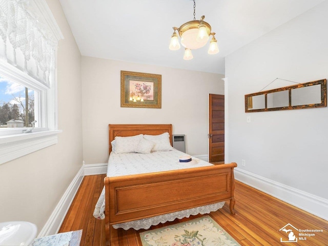 bedroom with hardwood / wood-style flooring and a notable chandelier