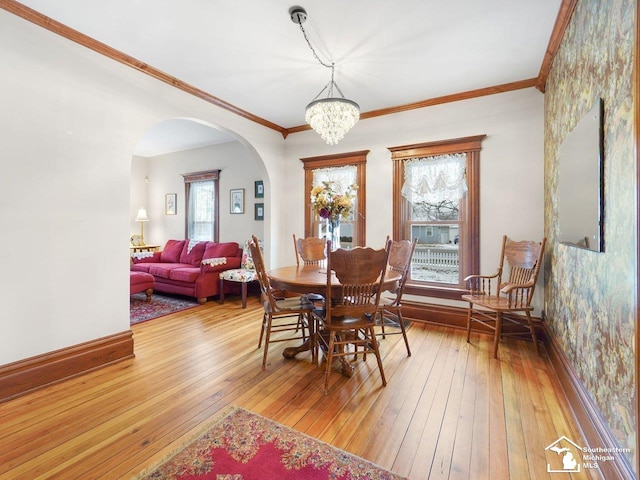 dining space featuring a notable chandelier, hardwood / wood-style floors, and crown molding