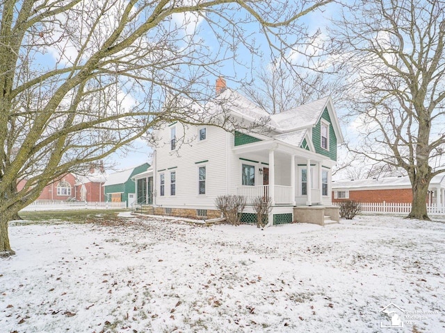 view of snowy exterior featuring covered porch