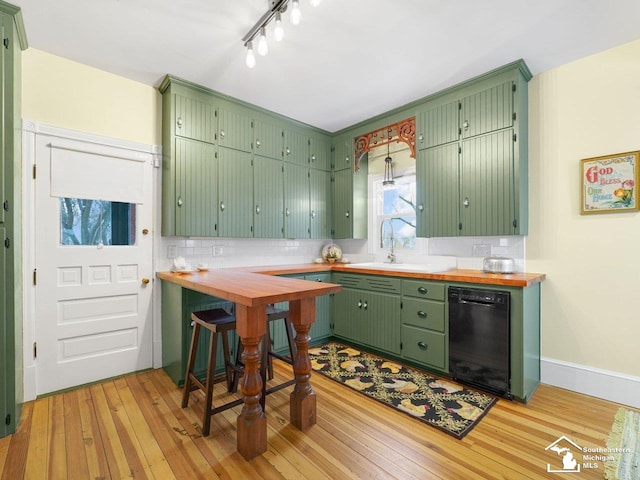 kitchen with dishwasher, light hardwood / wood-style flooring, and green cabinets