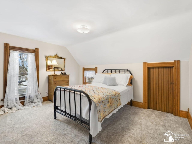 carpeted bedroom with lofted ceiling