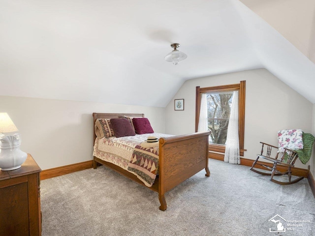 bedroom with vaulted ceiling and light carpet