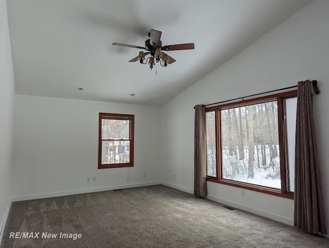 carpeted empty room featuring lofted ceiling, ceiling fan, and a wealth of natural light