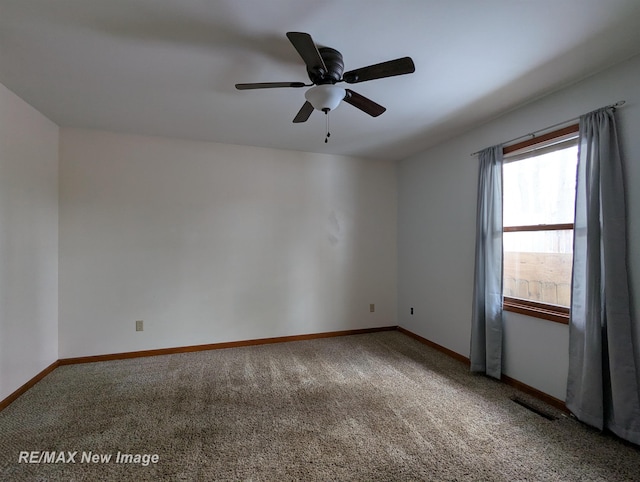 carpeted spare room featuring ceiling fan