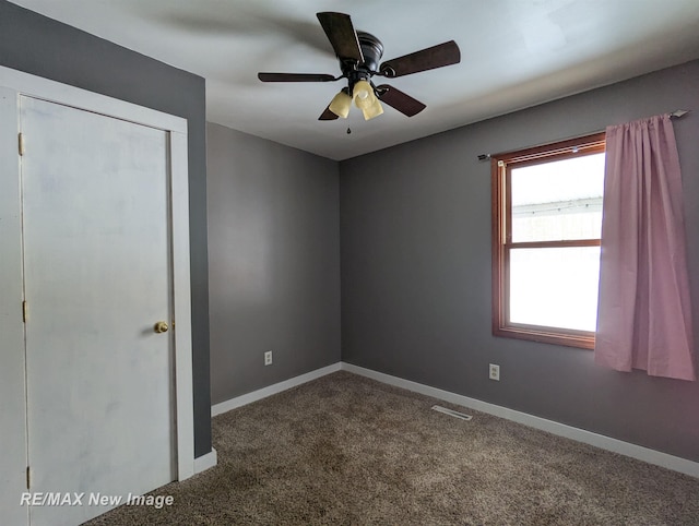 spare room featuring ceiling fan and carpet