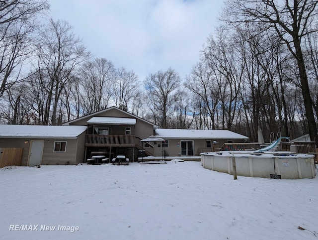 snow covered property with a pool side deck