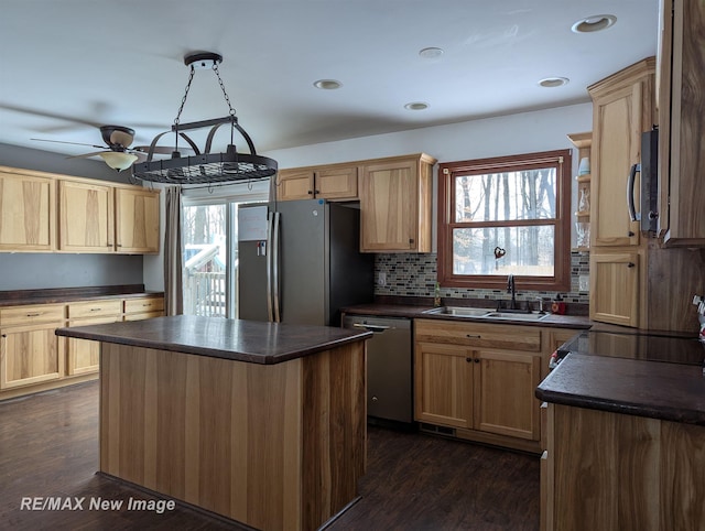 kitchen featuring ceiling fan, a center island, sink, dark wood-type flooring, and stainless steel appliances