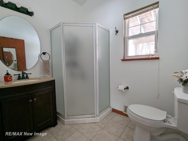 bathroom with toilet, vanity, tile patterned flooring, and a shower with door