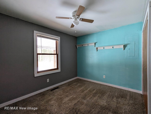 spare room with carpet, ceiling fan, and electric panel