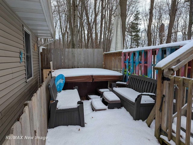 snow covered deck featuring a hot tub