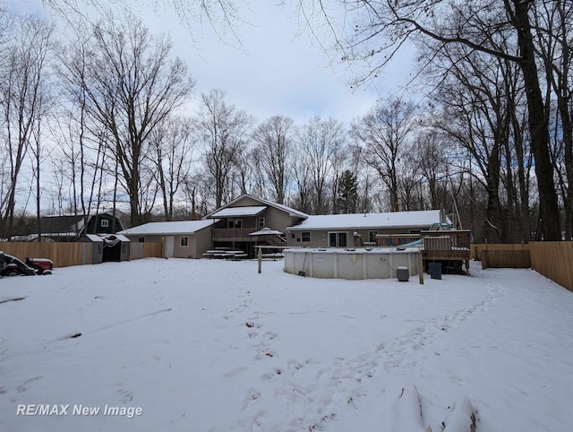 snow covered property with a swimming pool side deck